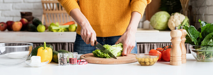 woman preparing greek salad in kitchen