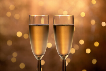Champagne glasses over holiday bokeh blinking background, glasses with sparkling wine, celebration, party. High quality 4k footage