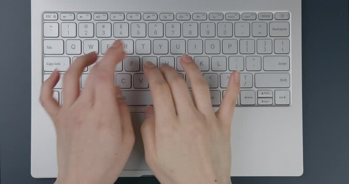 Flat lay. Close-up. Hands of a girl working on a laptop. Office table