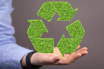 hand holding green recycle symbol