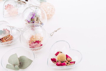 DIY ornaments filled with dried flowers on white background