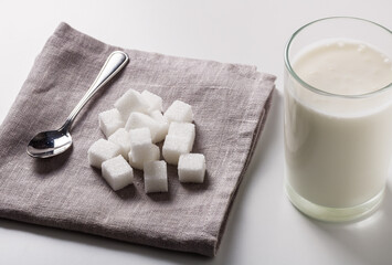 Natural yogurt and sugar lumps on a cloth napkin. Sugar-free yogurt.