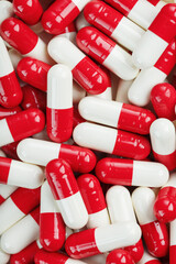 Medical medicinal Pills capsules are white and red in color as a background in full screen.