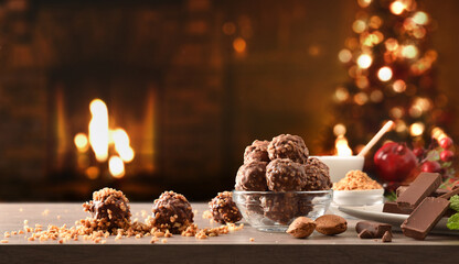 Preparing chocolate sweets with almonds on table at Christmas time
