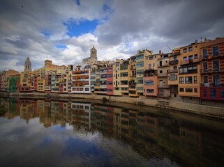 Fototapeta na wymiar Colorful historical houses,facades, reflected in water of the river Onyar, in Girona, Catalonia, Spain. 