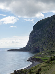 Fototapeta premium Overview ofthe amazing Fajã de Lopo Vaz, with cliffs, low platform by the sea and black sand beach. Flores Island.