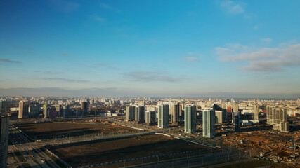 Fototapeta premium Construction site. Construction of modern multi-storey buildings. Against the background of the blue sky. Aerial photography.