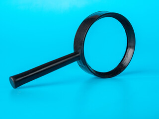 Magnifier on a blue background, close-up, selective focus, text magnification, age-related hyperopia