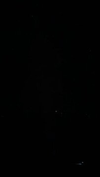 Fireworks in the window on the black sky. A picture of a snowflake flashes on the glass.