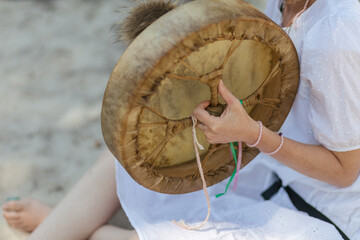 the girl's hand holds a shaman tambourine