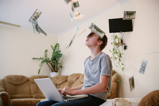 teenager dreams of big earnings. Falling from above bills on a young businessman. Cash bills pouring into the freelancer. Return of savings. Earnings of teenage schoolchildren without leaving home.
