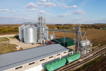 Aerial view of granaries. Grain storage and processing plant in countryside. Chrome colored granaries and buildings. Grain storage bins and other agricultural facilities in rural area