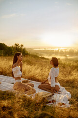 Fototapeta premium Two sexy women in lingerie on blanket in the field