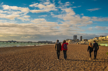 View of mature couple and  their teenage children walking on the beach in English seaside town 