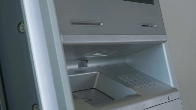 Male hand entering pin code on ATM keyboard, withdrawing money from account. HDR. Automatic machine for cash withdrawal.