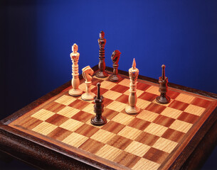 Chess pieces on a chessboard on a blue background