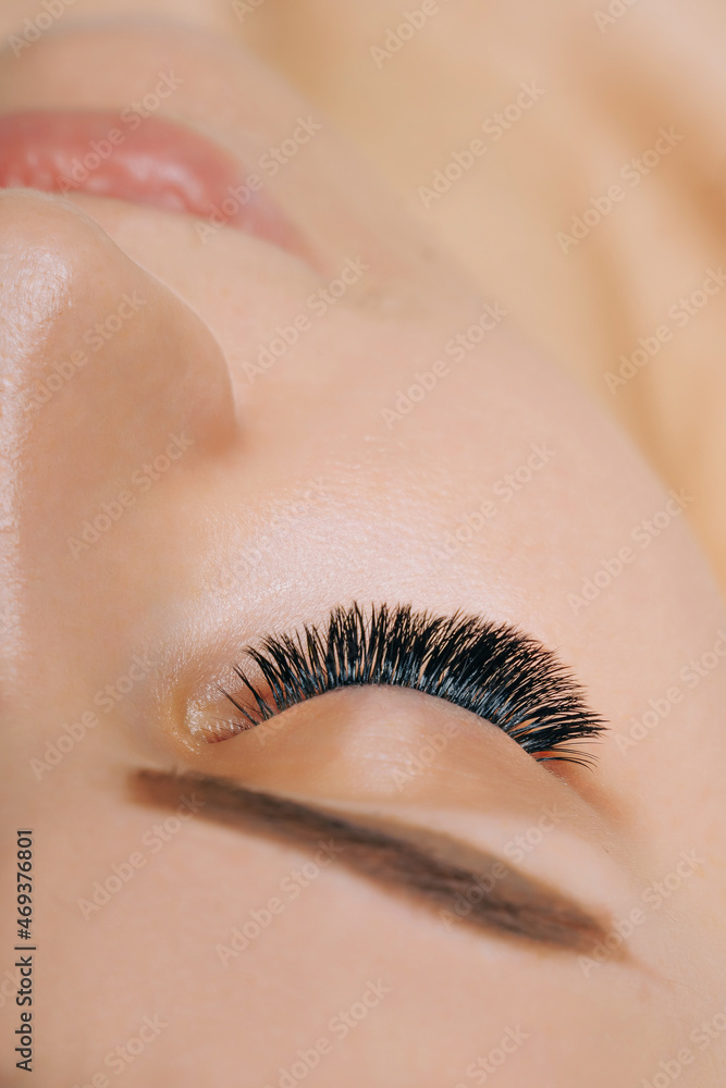 Wall mural Eyelash Extension Procedure. Woman Eye with Long Eyelashes. Close up, selective focus.