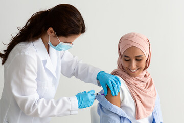 Vaccination Concept. Young Muslim Lady In Hijab Getting Vaccine Shot Against Covid-19