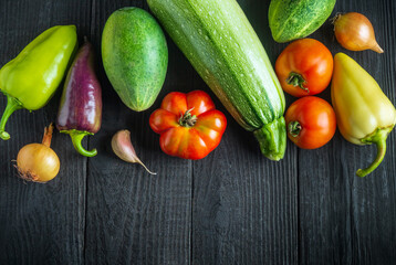 Big set of fresh vegetables for salad diet on a black table. Cooking salad in the restaurant kitchen. Free ad space.
