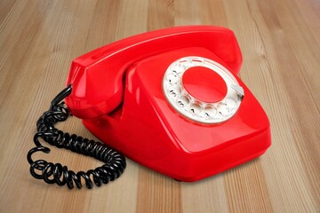 Old, red rotary dial retro telephone with receiver,