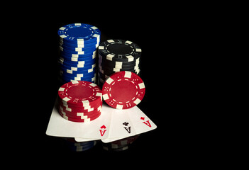 Poker game with three of kind or set combination. Chips and cards on black table. Successful and win three aces