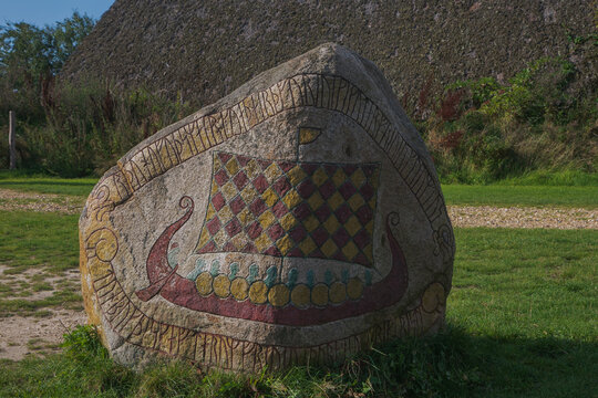 viking rune stone showing a colorful viking ship.
	