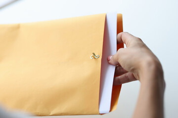 Woman hand takes out letter from envelope closeup