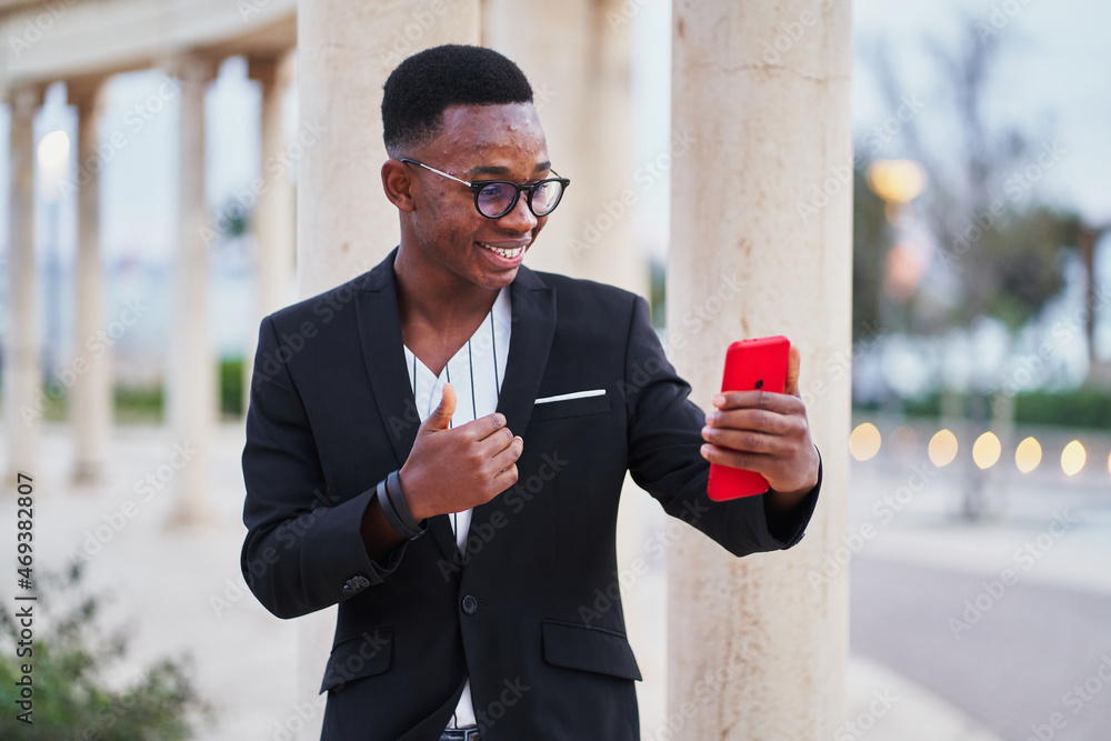 Wall mural black man having video call on smartphone