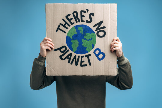 Unrecognizable Man Holding Carton Placard With Theres No Planet B And Hiding His Face Behind It In Front Of The Camera. Concept Of Eco Activism