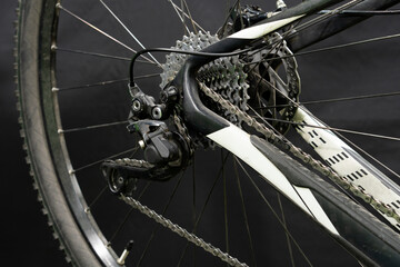 Obraz premium Mountain bike repair in the workshop. Mechanic's hands and tool close-up. The mechanic cuts off the old rear derailleur cable. A small business in the garage.