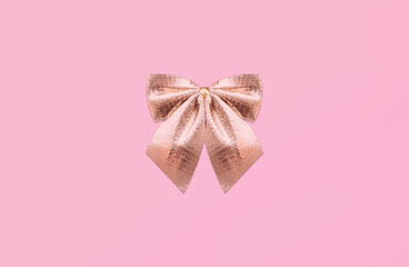 Gold bow tie. Template with copy space. Shining atlas decorative bow on pink backdrop