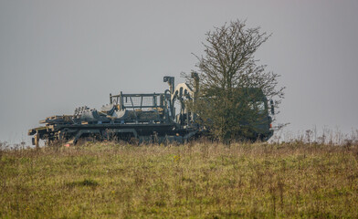 Fototapeta premium MAN SV 8x8 army logistics truck vehicle with cargo driving along a mud track in action on a military exercise, Salisbury Plain UK