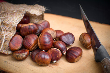 chestnuts out of the pouch on wooden floor with knife