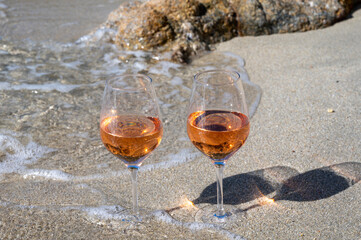Summer time in Provence, two glasses of cold rose wine on sandy beach near Saint-Tropez, Var department, France
