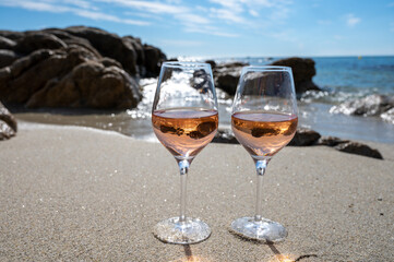 Summer time in Provence, two glasses of cold rose wine on sandy beach near Saint-Tropez, Var department, France