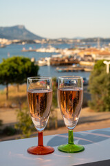 Summer party, drinking of French champagne rose sparkling wine in glasses with view on fishermen harbour of Toulon, France