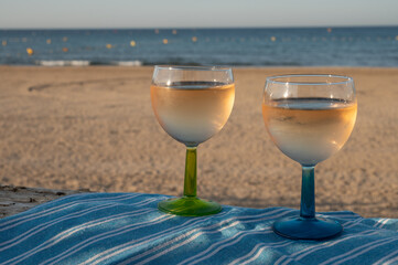 Summer time in Provence, drinking of cold gris rose wine on sandy beach and blue sea near Toulon, Var department, France