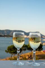 Summer on French Riviera, drinking cold white wine from Cotes de Provence on outdoor terrase with view on harbour of Toulon, Var, France