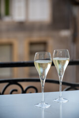 Romantic party with two glasses of white cold champagne and view on old street in French village