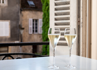 Romantic party with two glasses of white cold champagne and view on old street in French village
