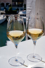 Summer on French Riviera Cote d'Azur, drinking cold dry white wine from Cotes de Provence on outdoor terrase in Port Grimaud, Var, France