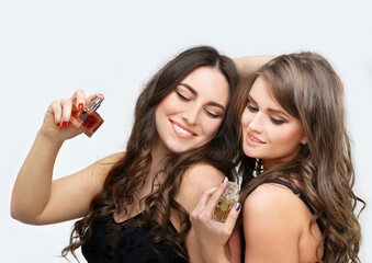 Perfume. Young girls smelling aroma with pleasure