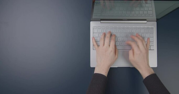 Office table. Hands of a girl working on a laptop. Flat lay. Copy space