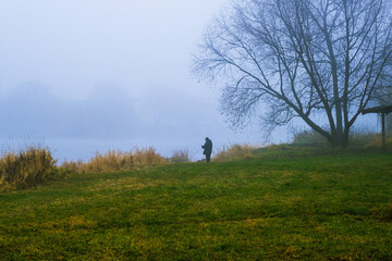 Fisherman on the pond in a fog