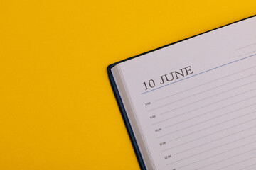 Notepad or diary with the exact date on a yellow background. Calendar for June 10 - summer time. Space for text.