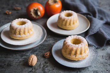 Mini Kaki and walnut bundt cakes with powdered sugar