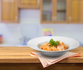 Tasty pasta dish with tomato sauce and cheese on the desk