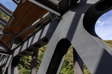 A fragment of a metal structure of a pedestrian crossing over a river or highway. Angular...