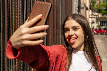 Close up portrait of a young attractive woman holding a smartphone digital camera with her hands...