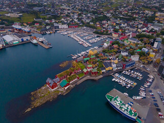 Obraz premium Beautiful aerial view of the City of Torshavn Capital of Faroe Islands- View of Cathedral, colorful buildings, marina, suburbs and Flag